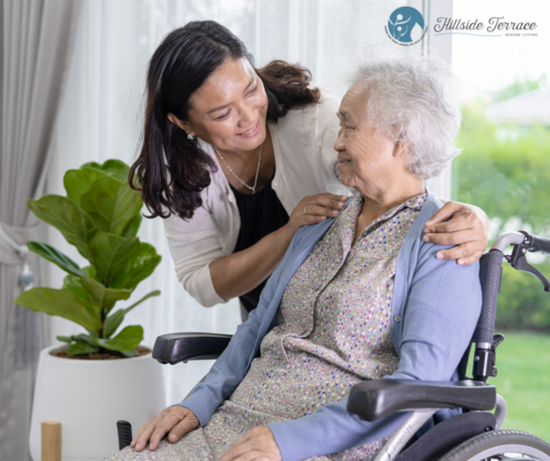 A caregiver smiling at an elderly woman in a wheelchair.