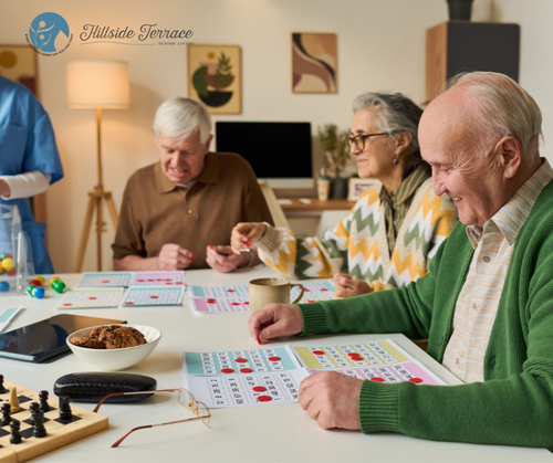 Older adults seated around a table playing a board game with colorful cards and chips, with a bowl of snacks on the table, in a warmly lit living room.