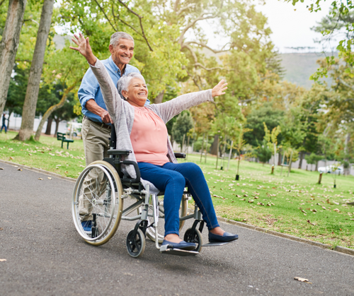 a happy woman being pushing in a wheelchair